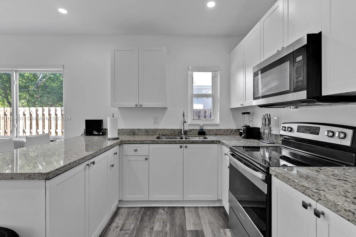 a kitchen with stainless steel appliances granite countertop a stove microwave and sink