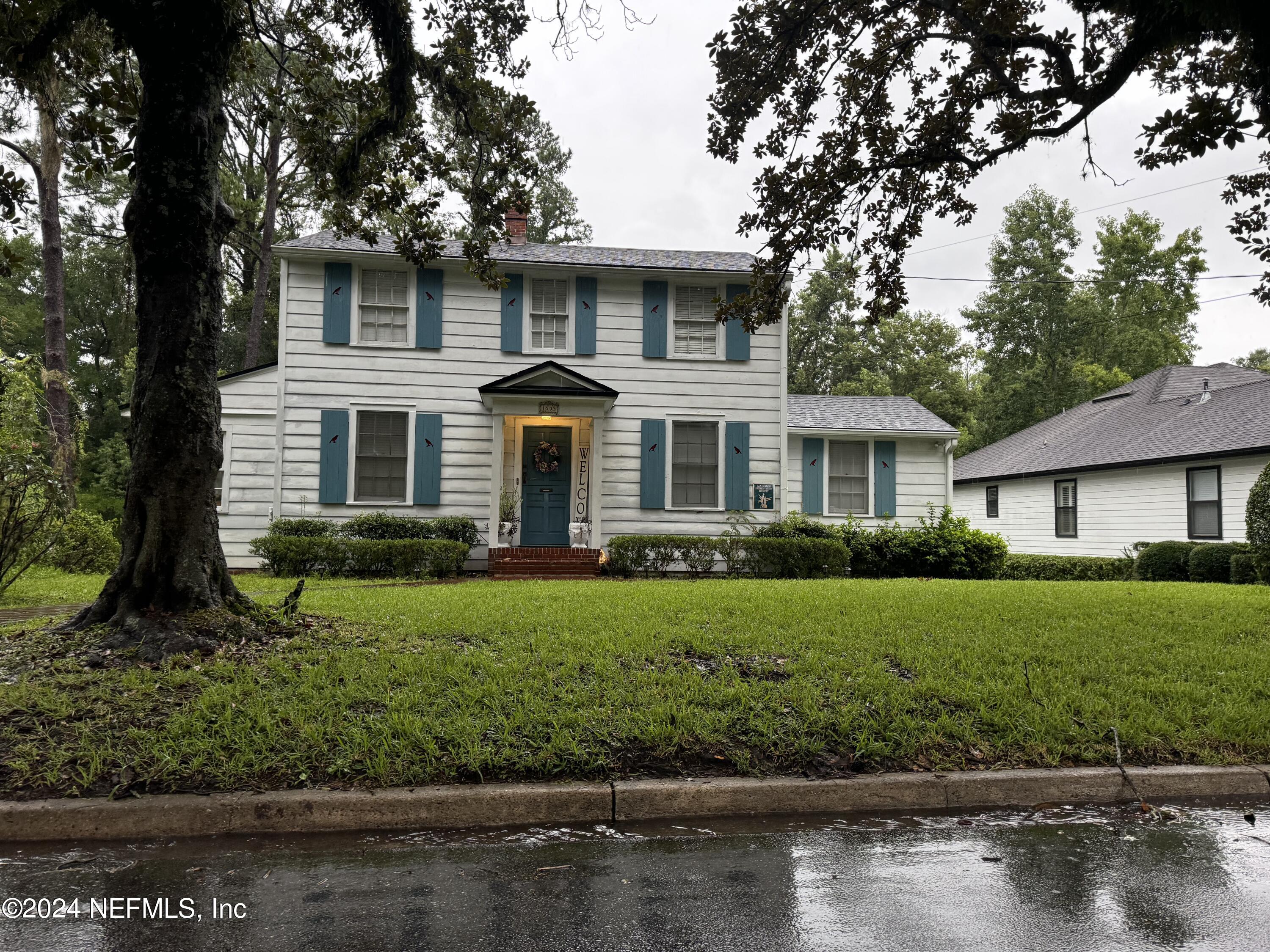 a front view of a house with a yard and lake view