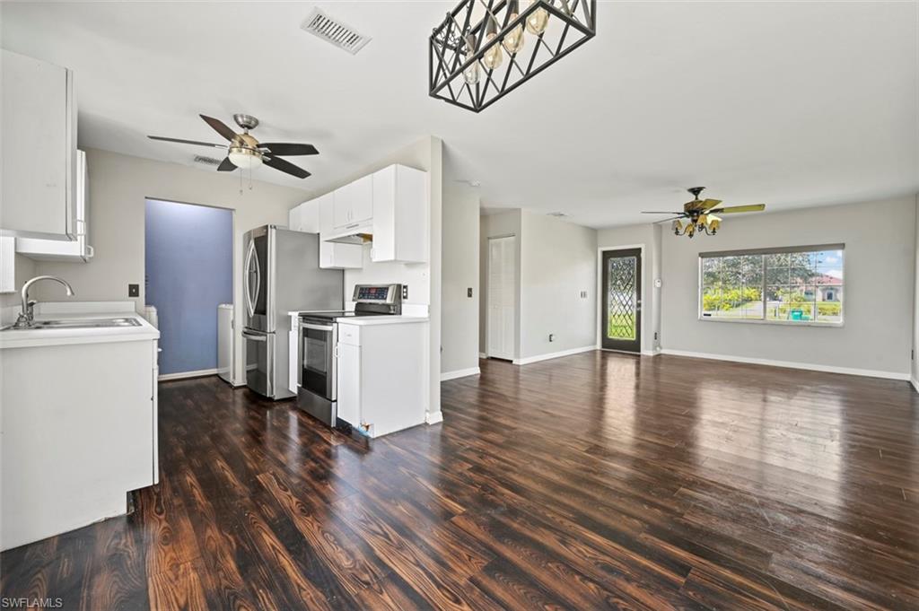 a view of a kitchen with wooden floor and a kitchen space