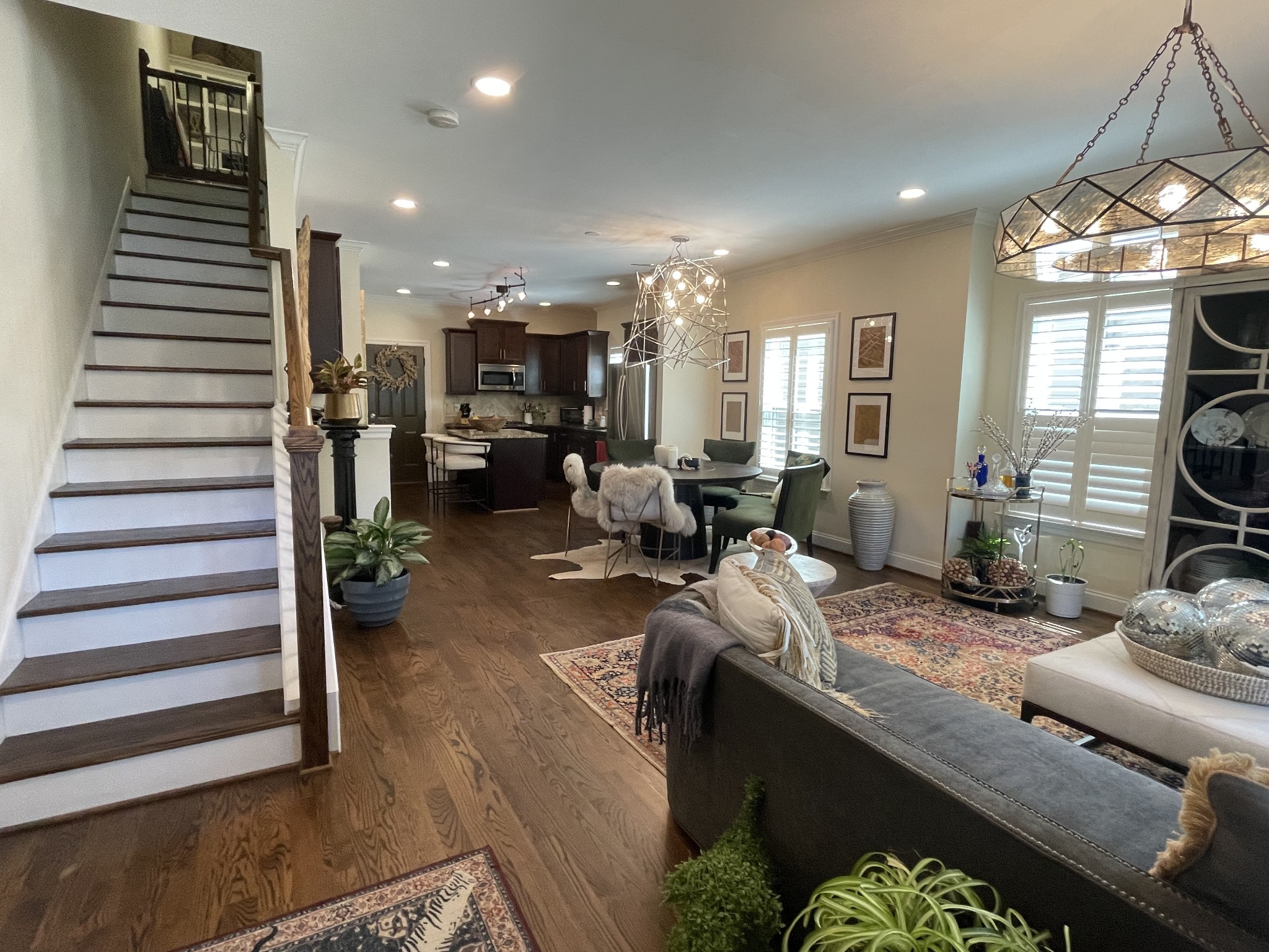 a living room with furniture kitchen view and a large window