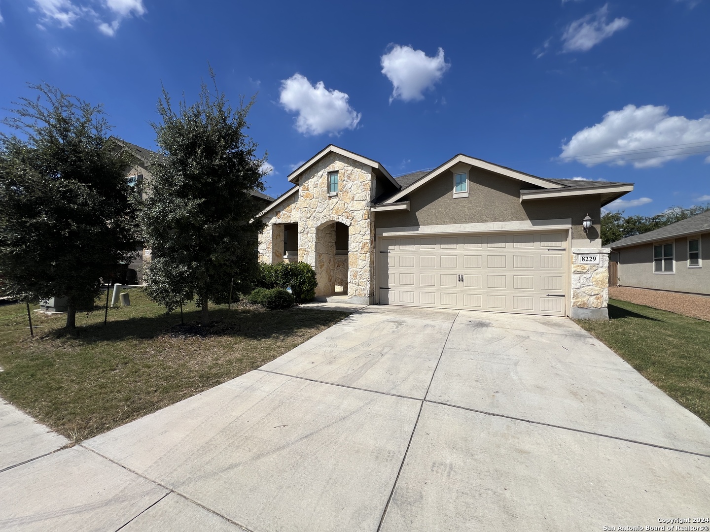 a front view of a house with a yard and garage