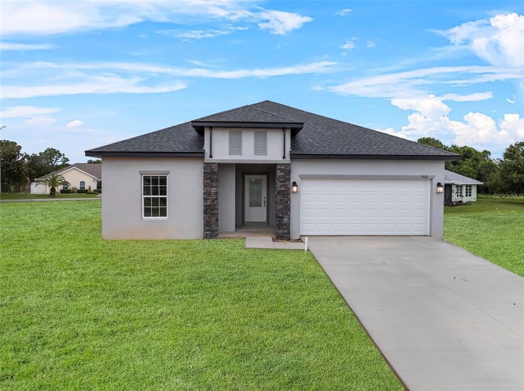 a front view of a house with a yard and garage