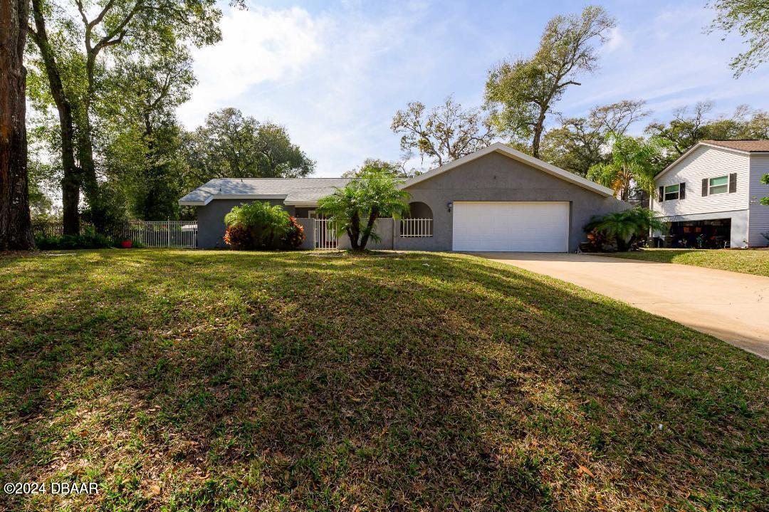 a front view of a house with a yard and garage