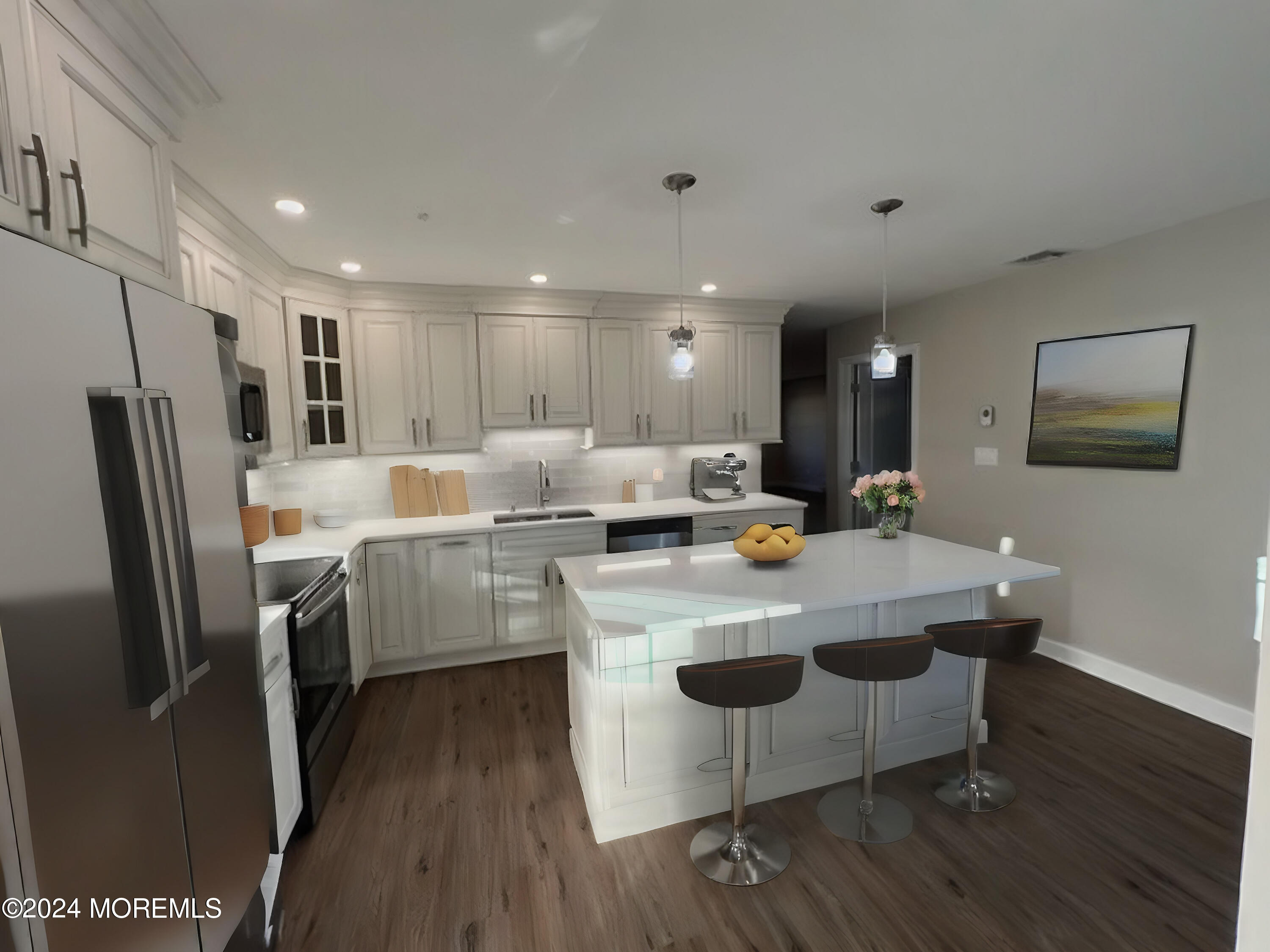 a kitchen with kitchen island stainless steel appliances a sink a stove a refrigerator and cabinets