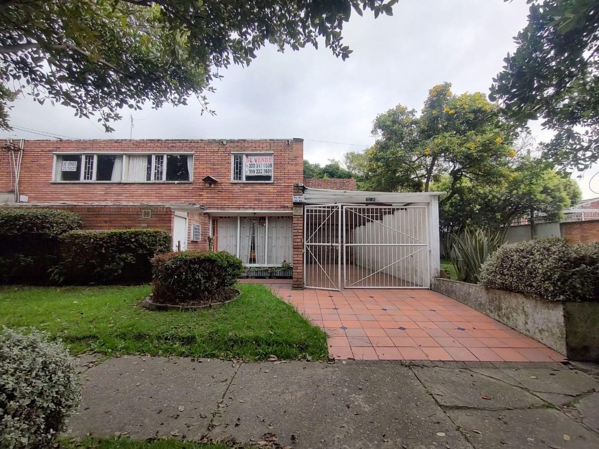 a front view of a house with a garden and yard