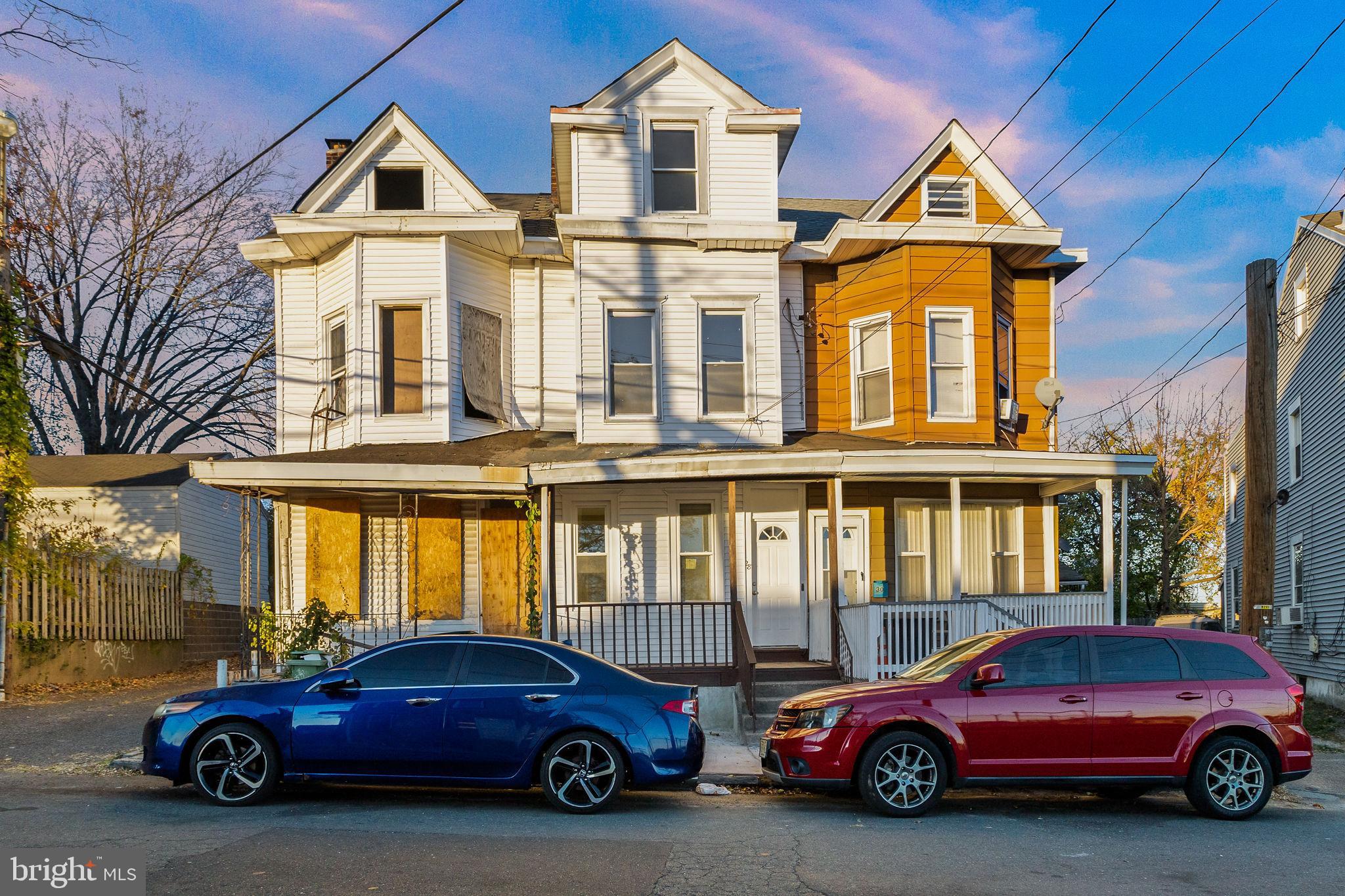 a front view of a residential apartment building with cars parked