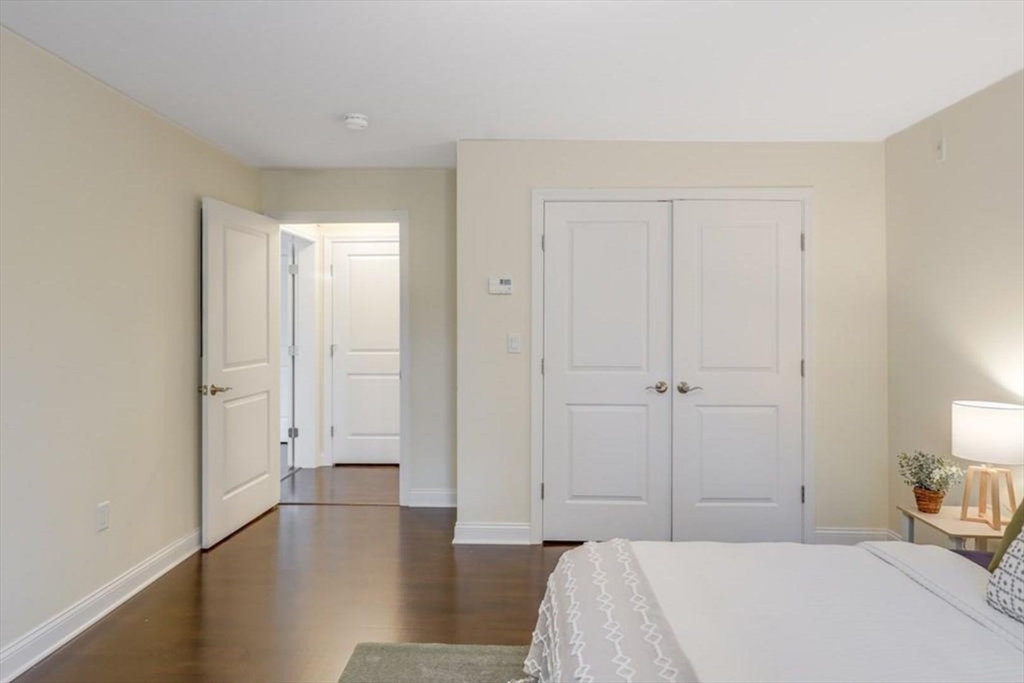 a view of a bedroom with a bed and wooden floor