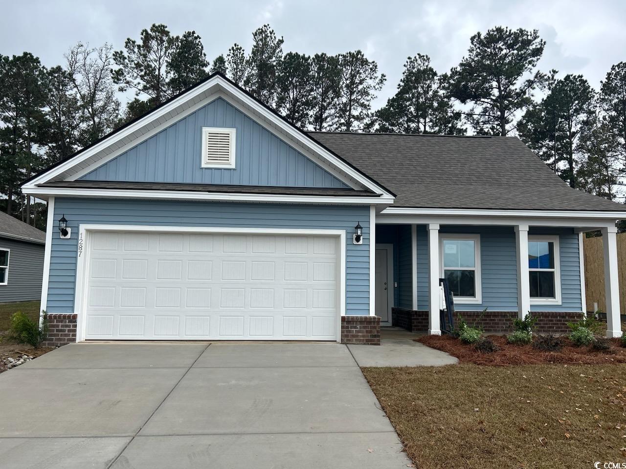 Craftsman-style home featuring a garage and a porc