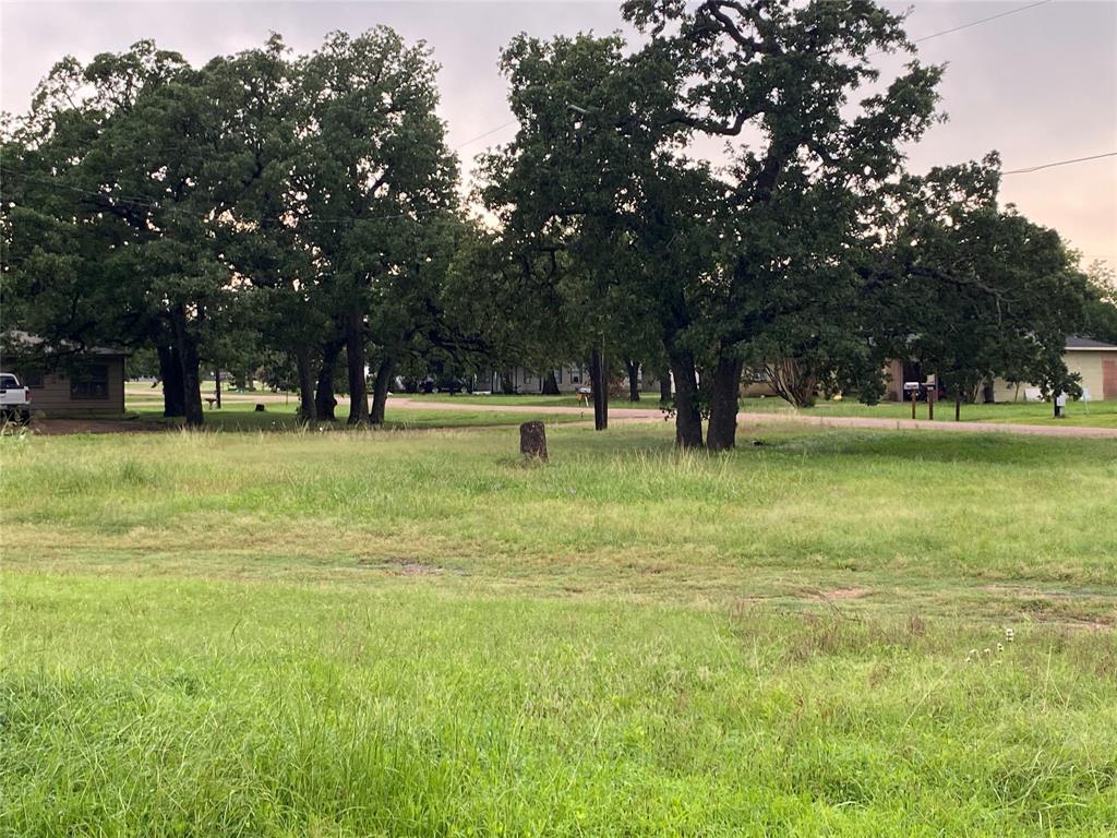 a view of pool with lawn chairs and trees