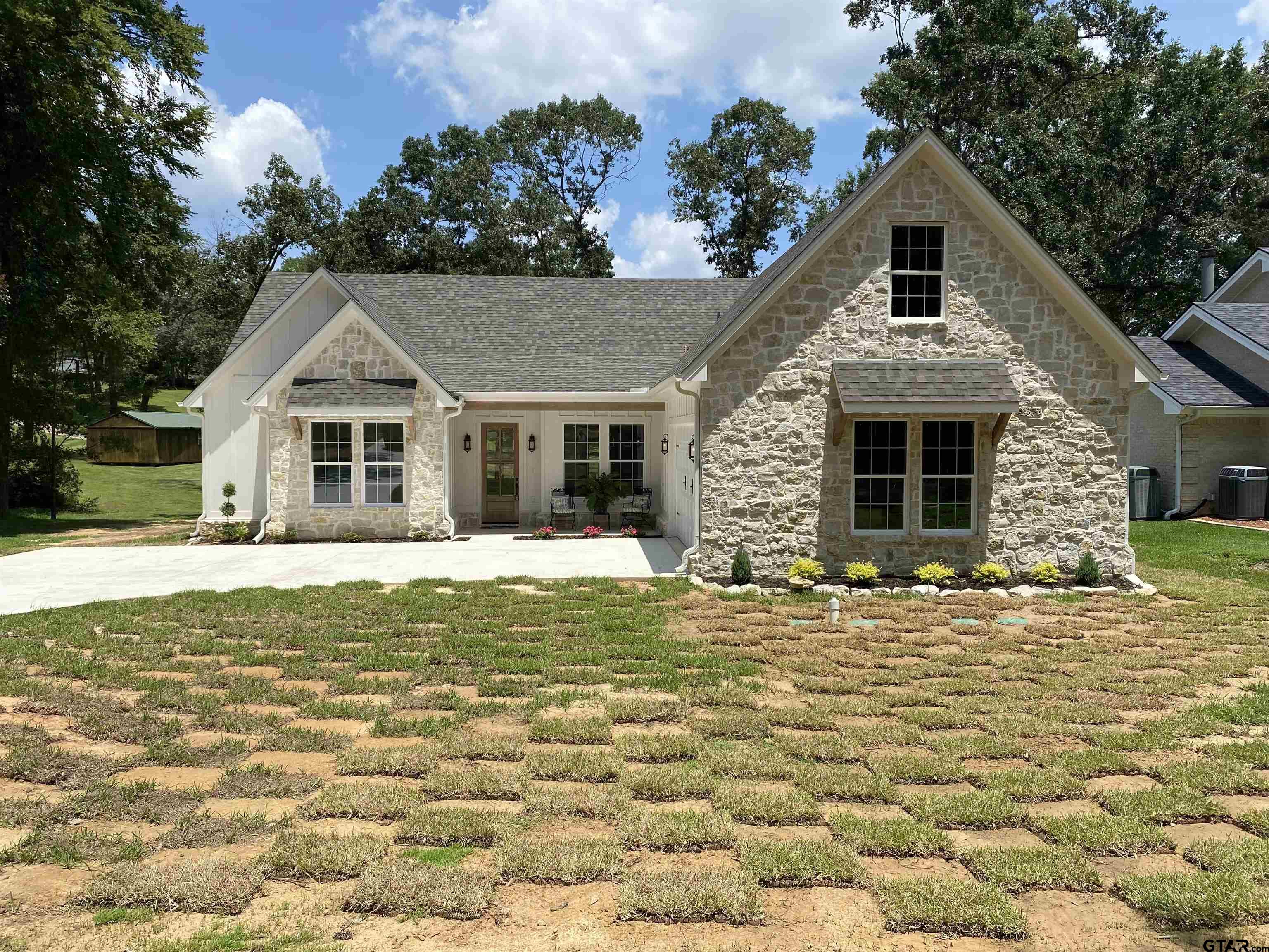 a front view of a house with a garden