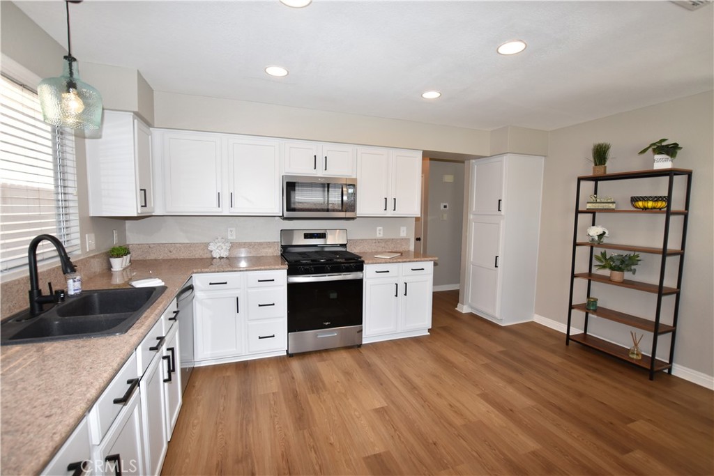 a kitchen with stainless steel appliances a sink a stove a refrigerator and cabinets