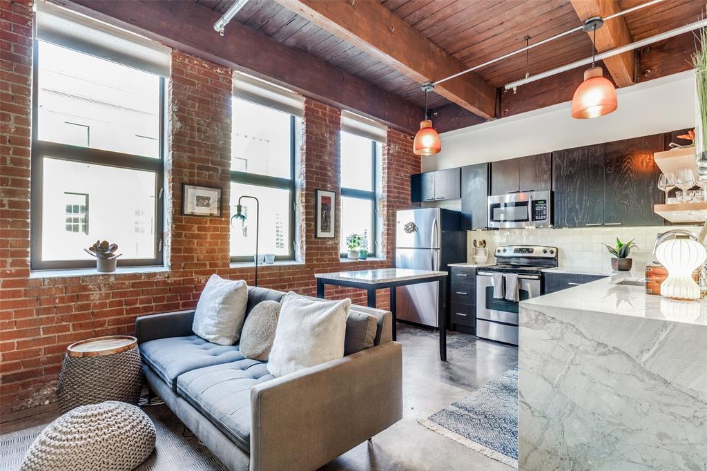 a living room with furniture wooden floor and kitchen view