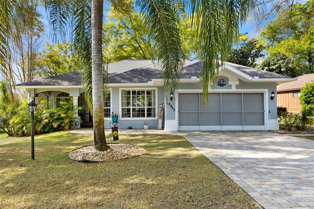 a front view of a house with a yard and potted plants