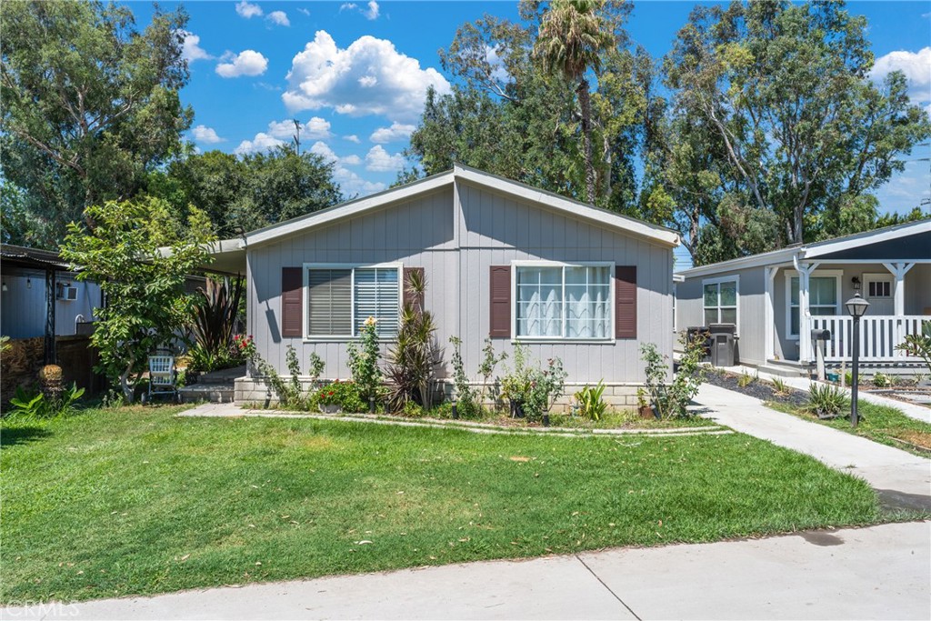 a front view of a house with a yard and trees