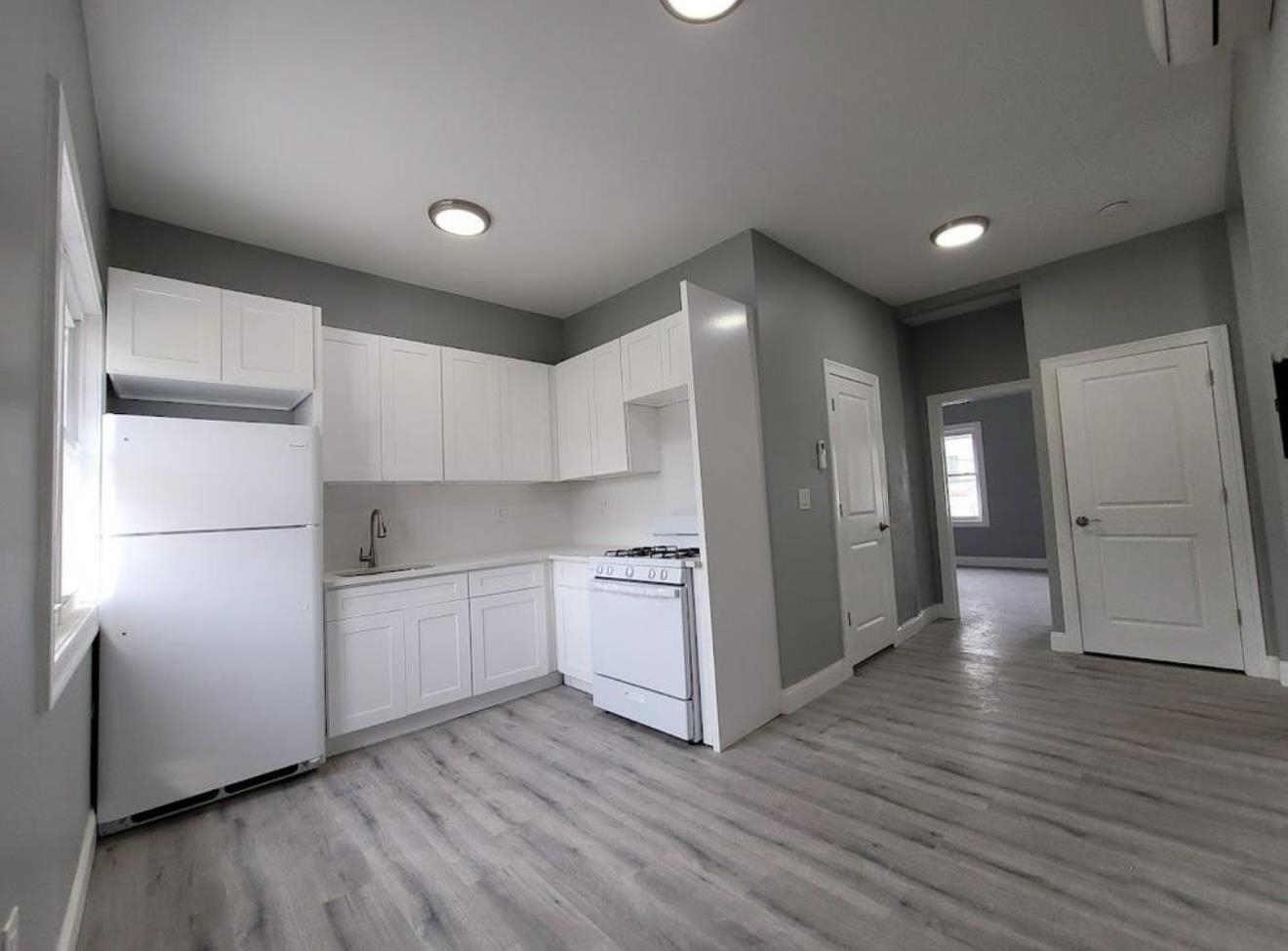 a kitchen with a refrigerator and a stove top oven