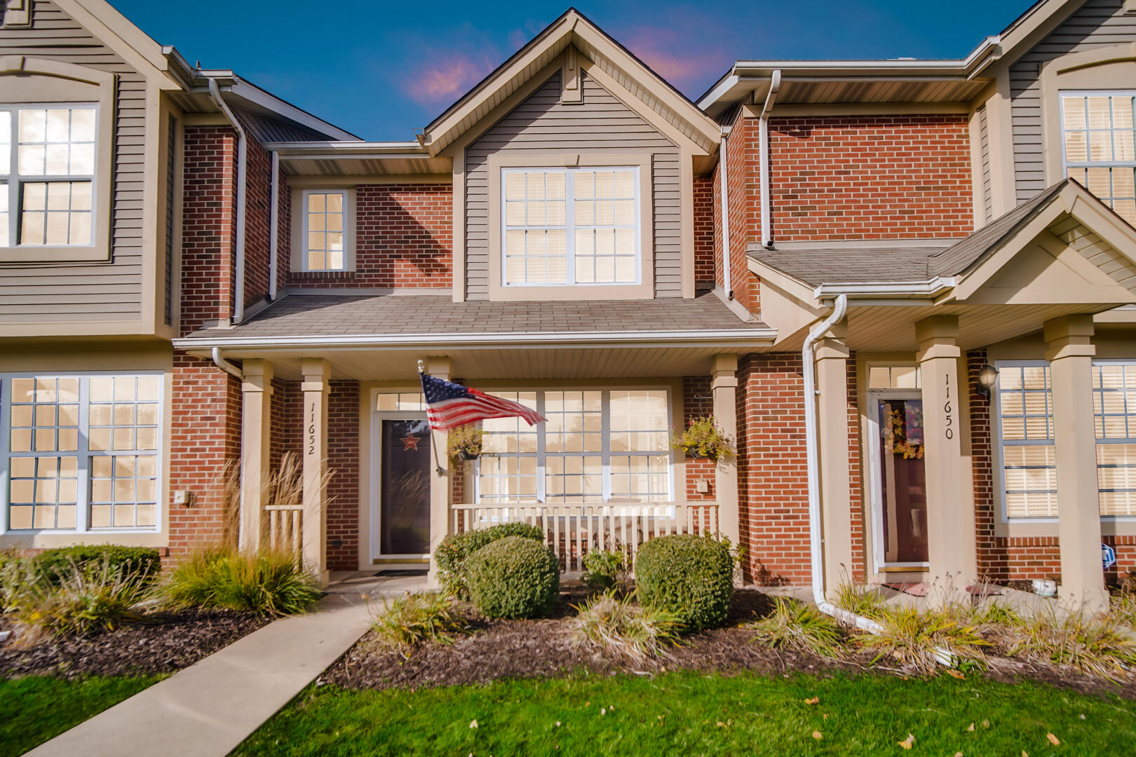 a front view of a house with a yard and plants