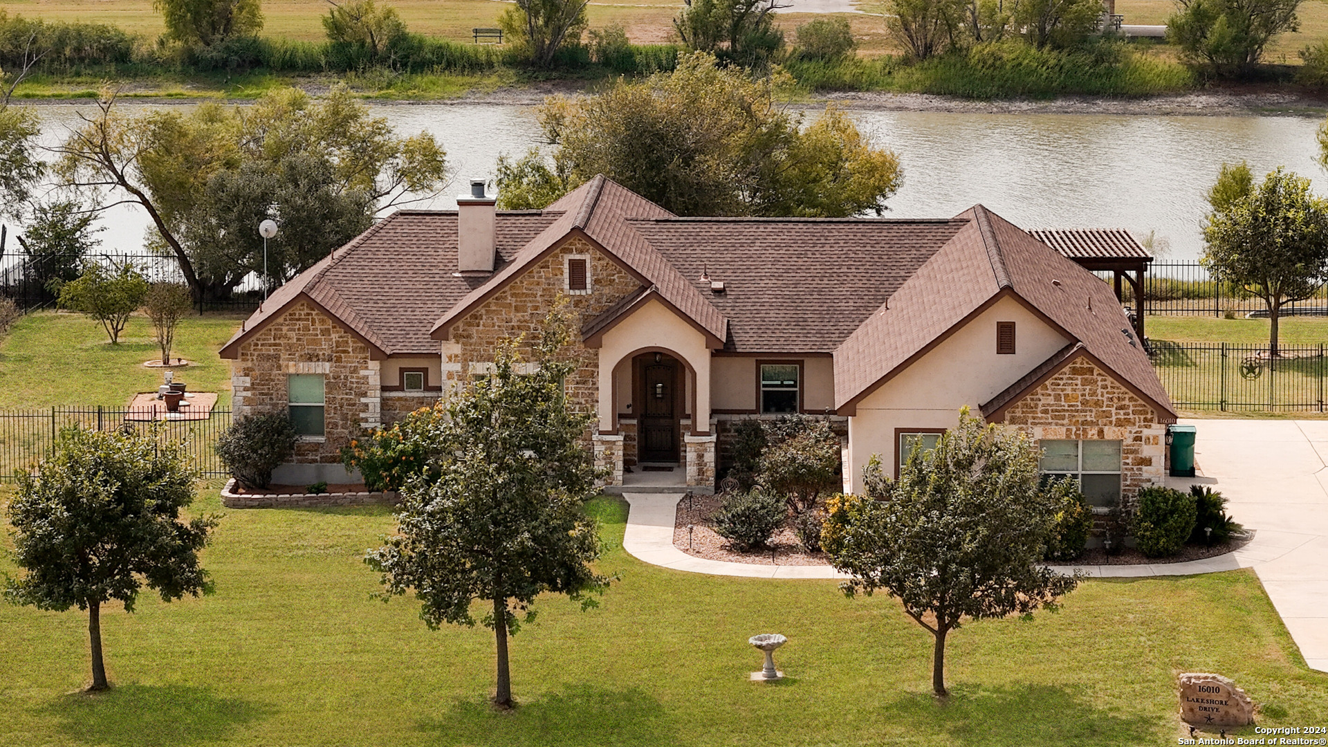 a aerial view of a house with lake view and a trees