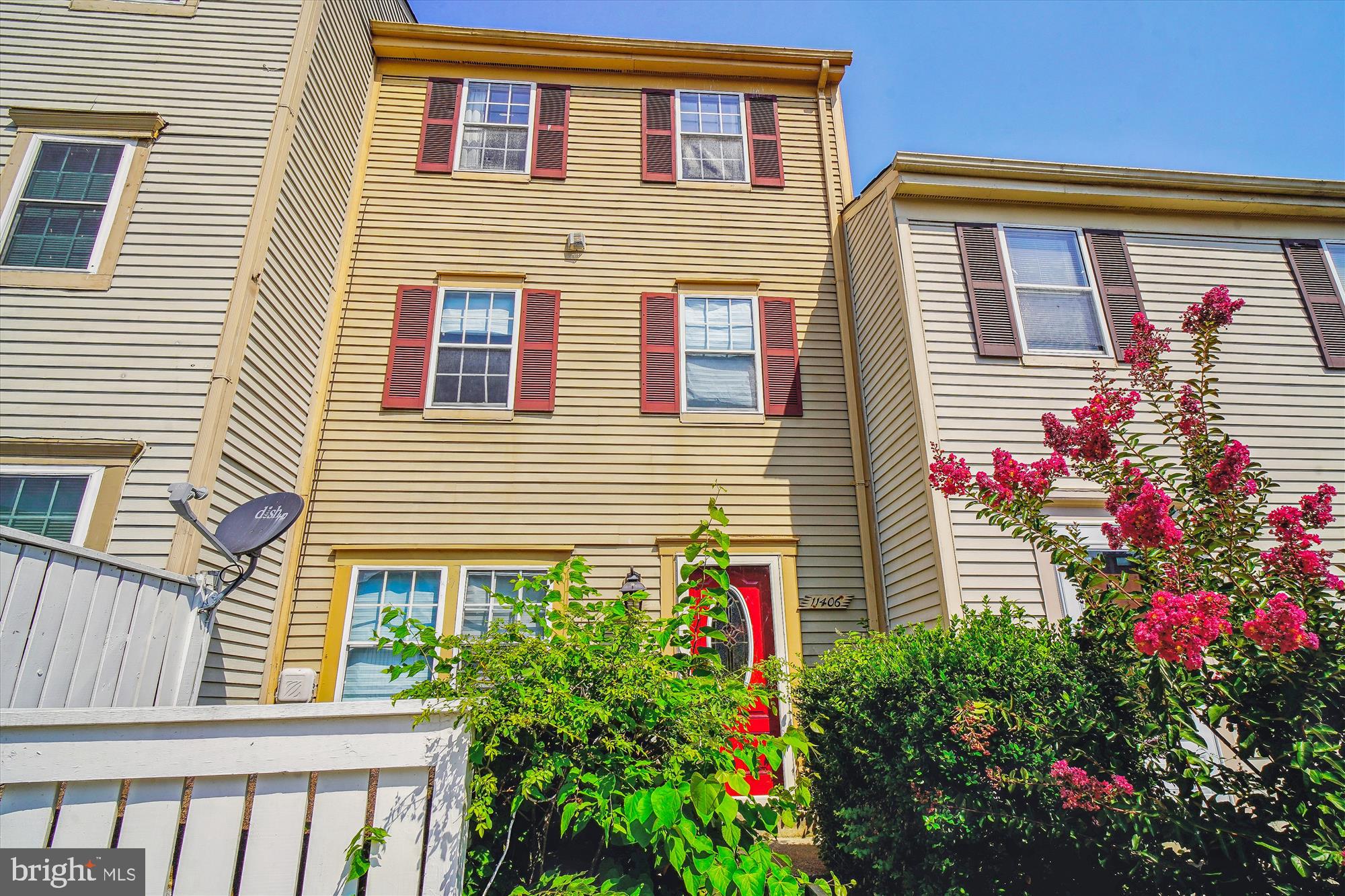 a front view of a house with many windows and flowers