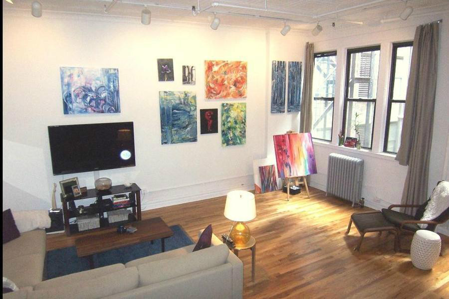 a living room with furniture and a flat screen tv with wooden floor