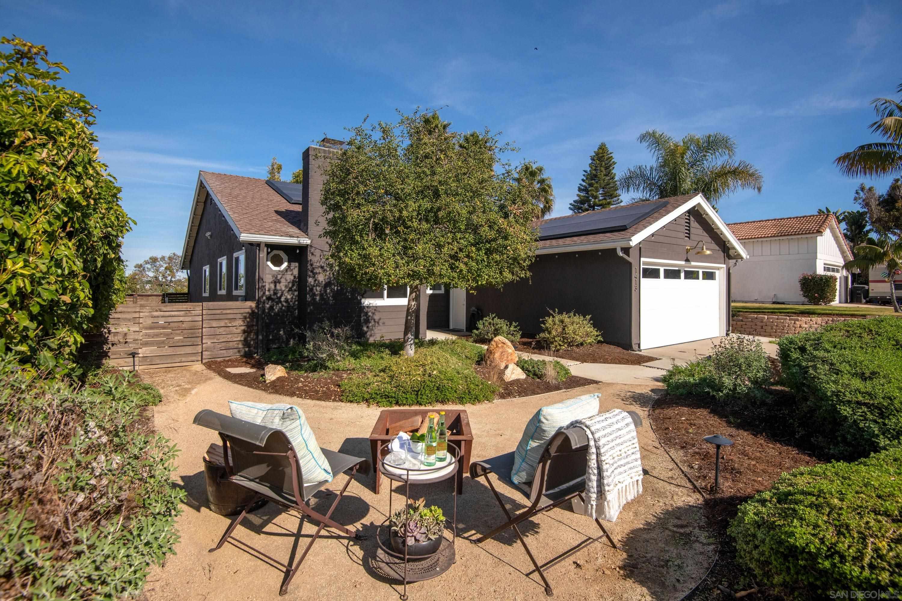 a view of a house with backyard and sitting area