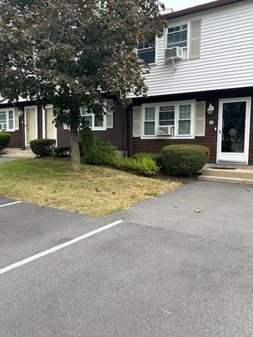 a view of a house with a yard and large tree