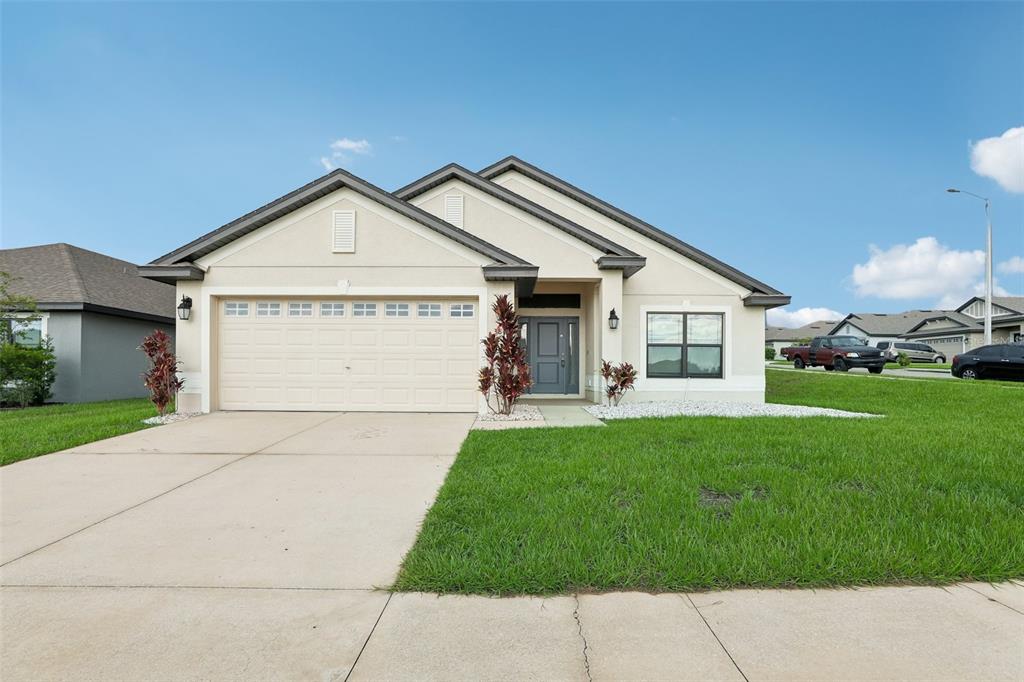 a front view of a house with a yard and garage