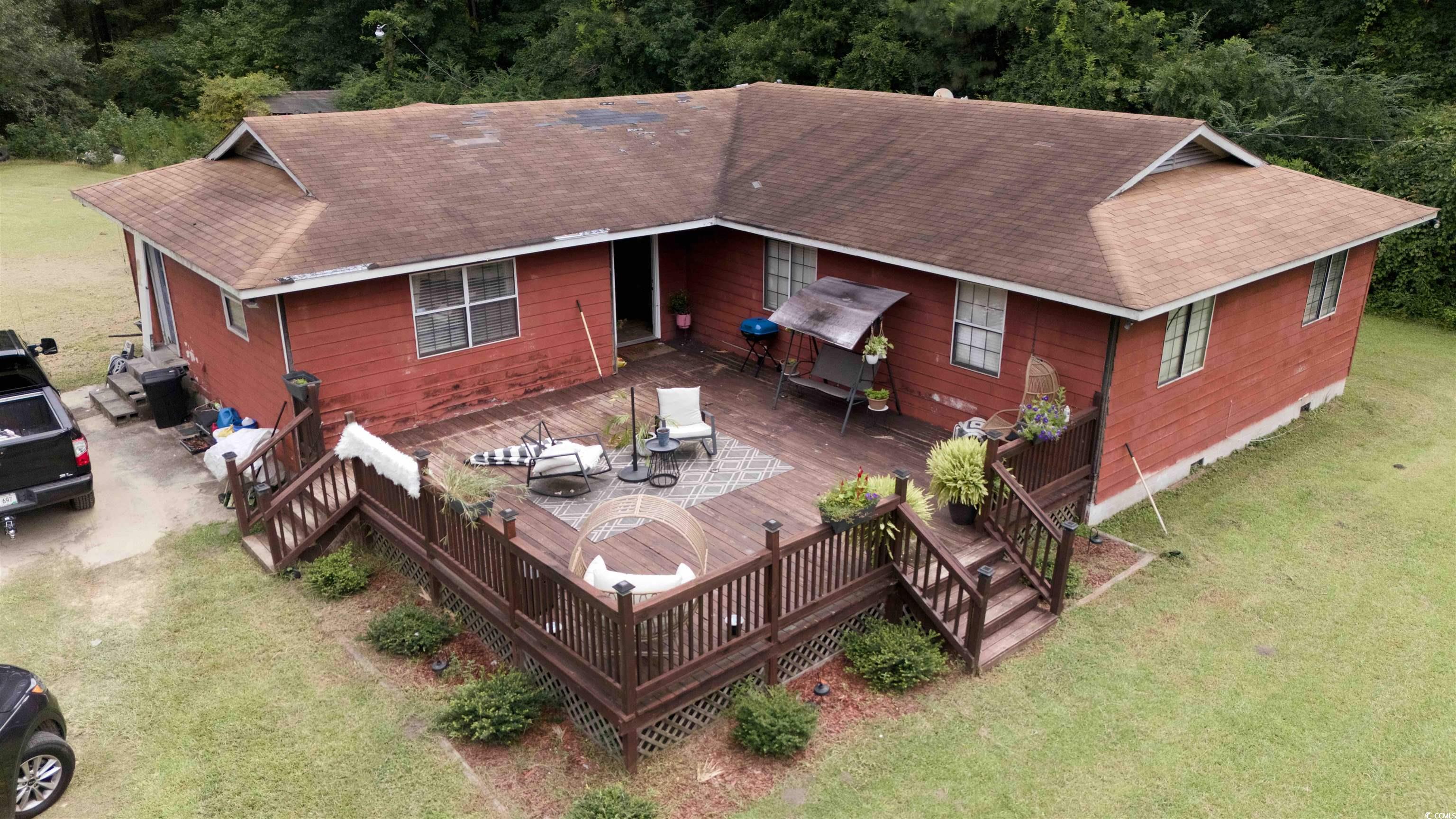 Back of property with a deck and a lawn