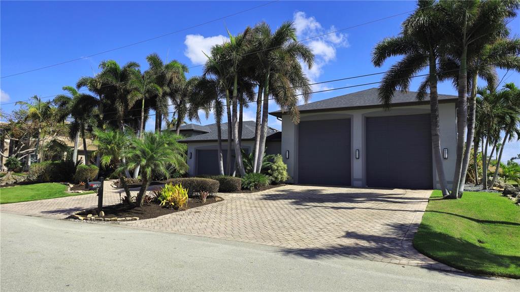 a view of a house with a yard and palm trees