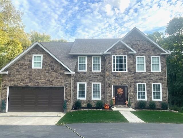 a front view of a house with a yard and garage