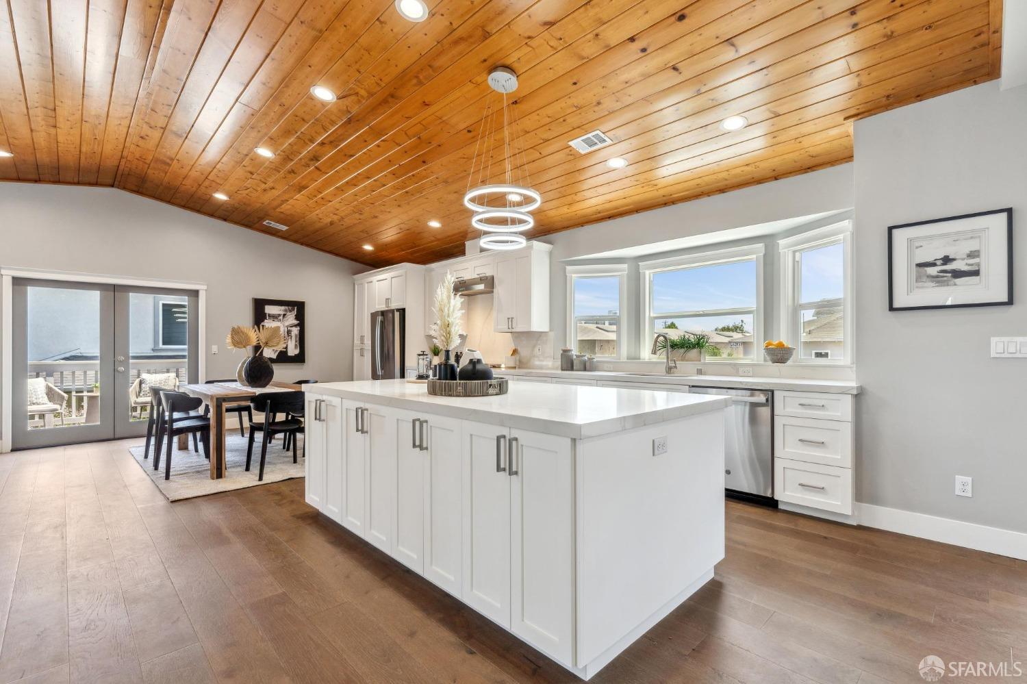 a large white kitchen with lots of counter space and chandelier