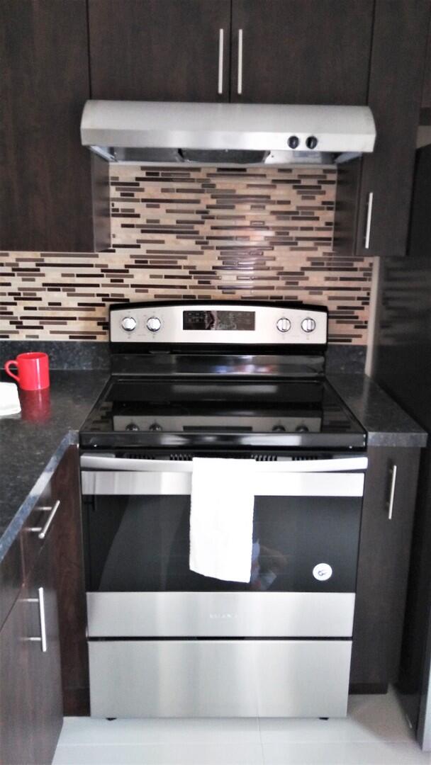 a stove top oven sitting inside of a kitchen