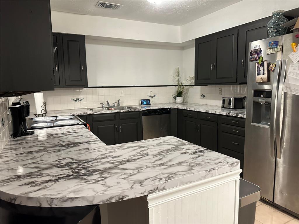 a kitchen with granite countertop a sink stainless steel appliances and cabinets