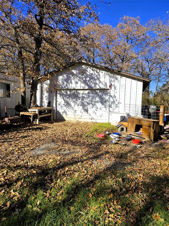 a view of a backyard with table and chairs under a large tree