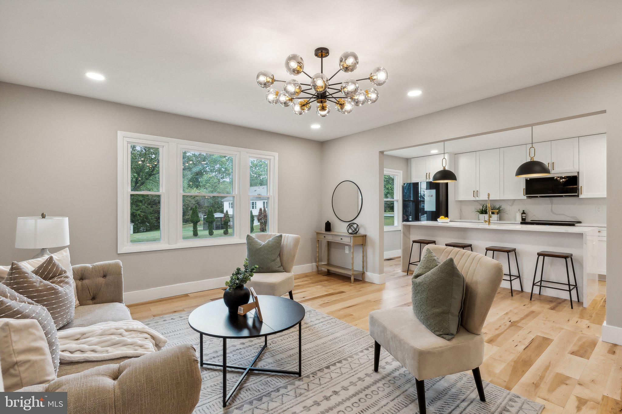 a living room with furniture a chandelier and a flat screen tv