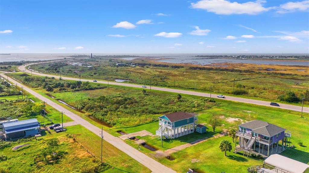 This aerial image showcases available properties adjacent to State Highway 87 with proximity to a ferry, highlighting both residential and commercial opportunities in a coastal area with expansive views.