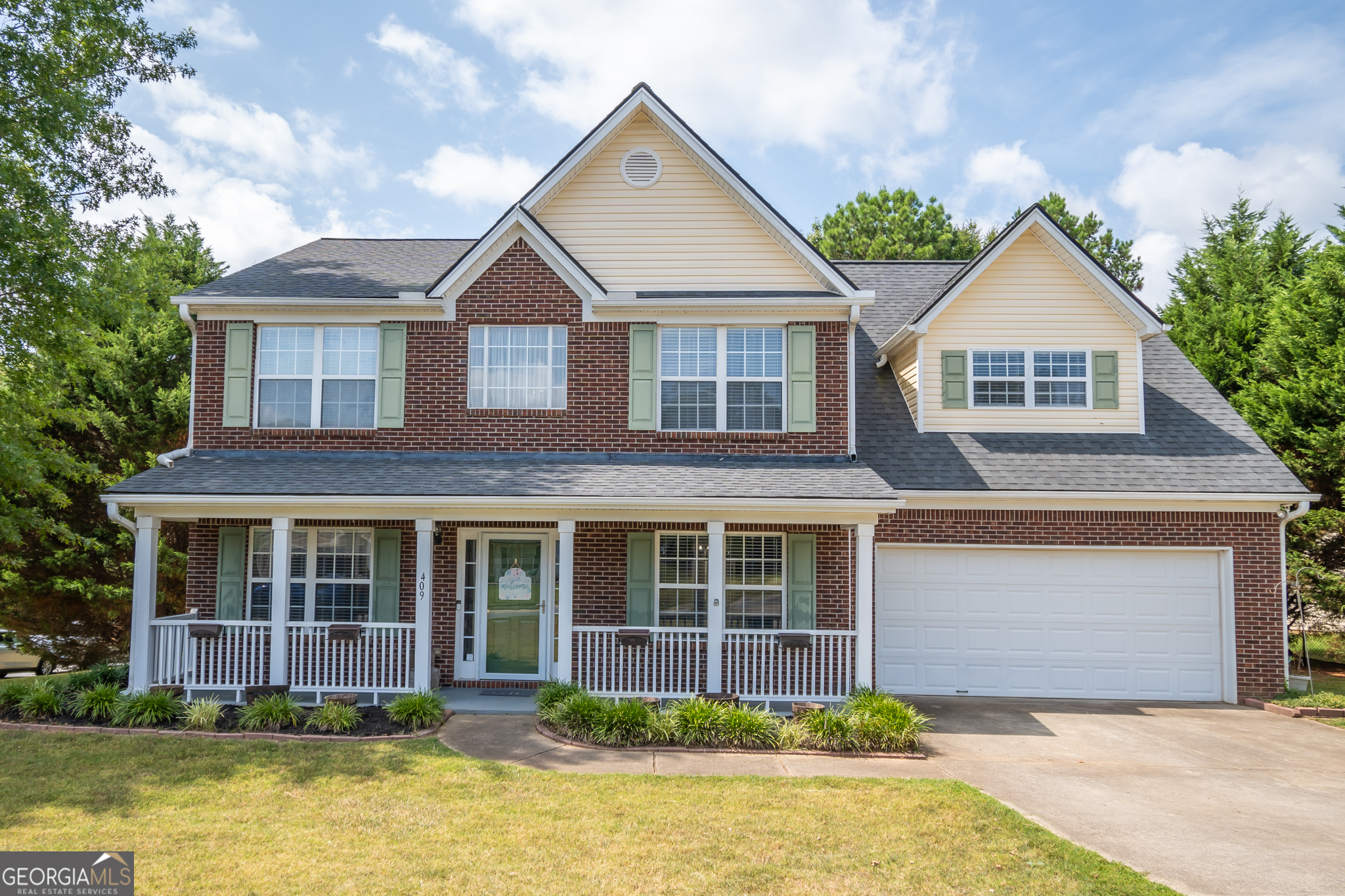 a front view of a house with a yard and garage