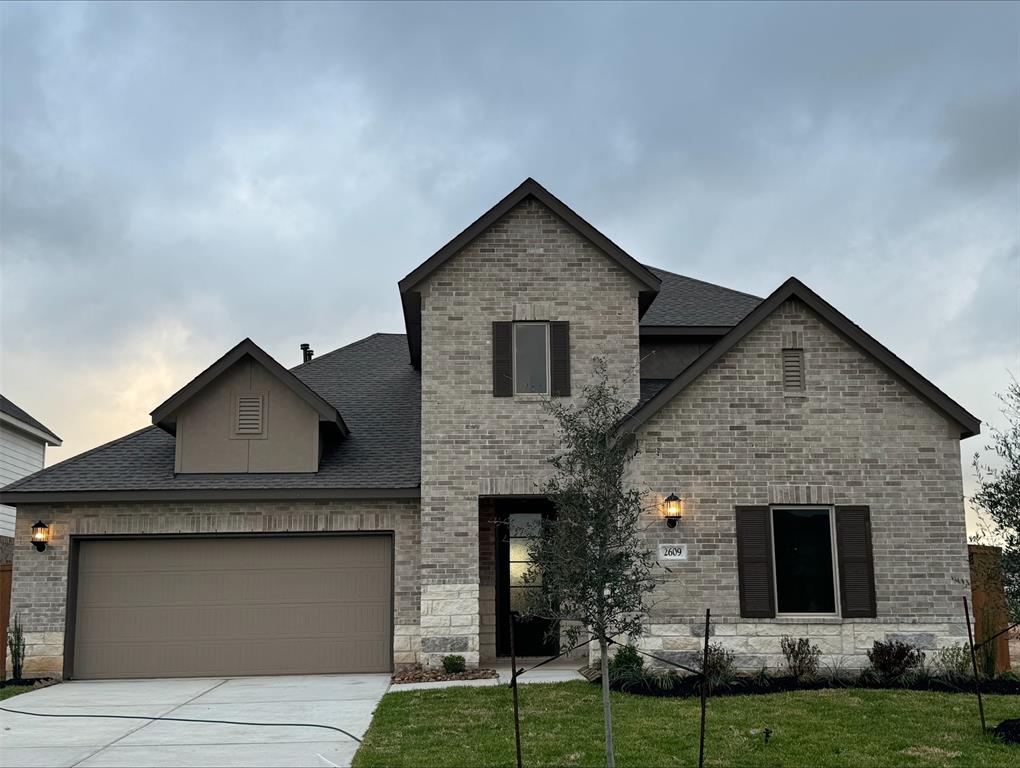 a front view of a house with a yard and garage