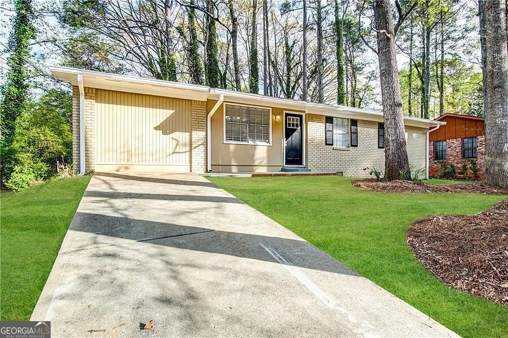 a front view of a house with a yard and trees