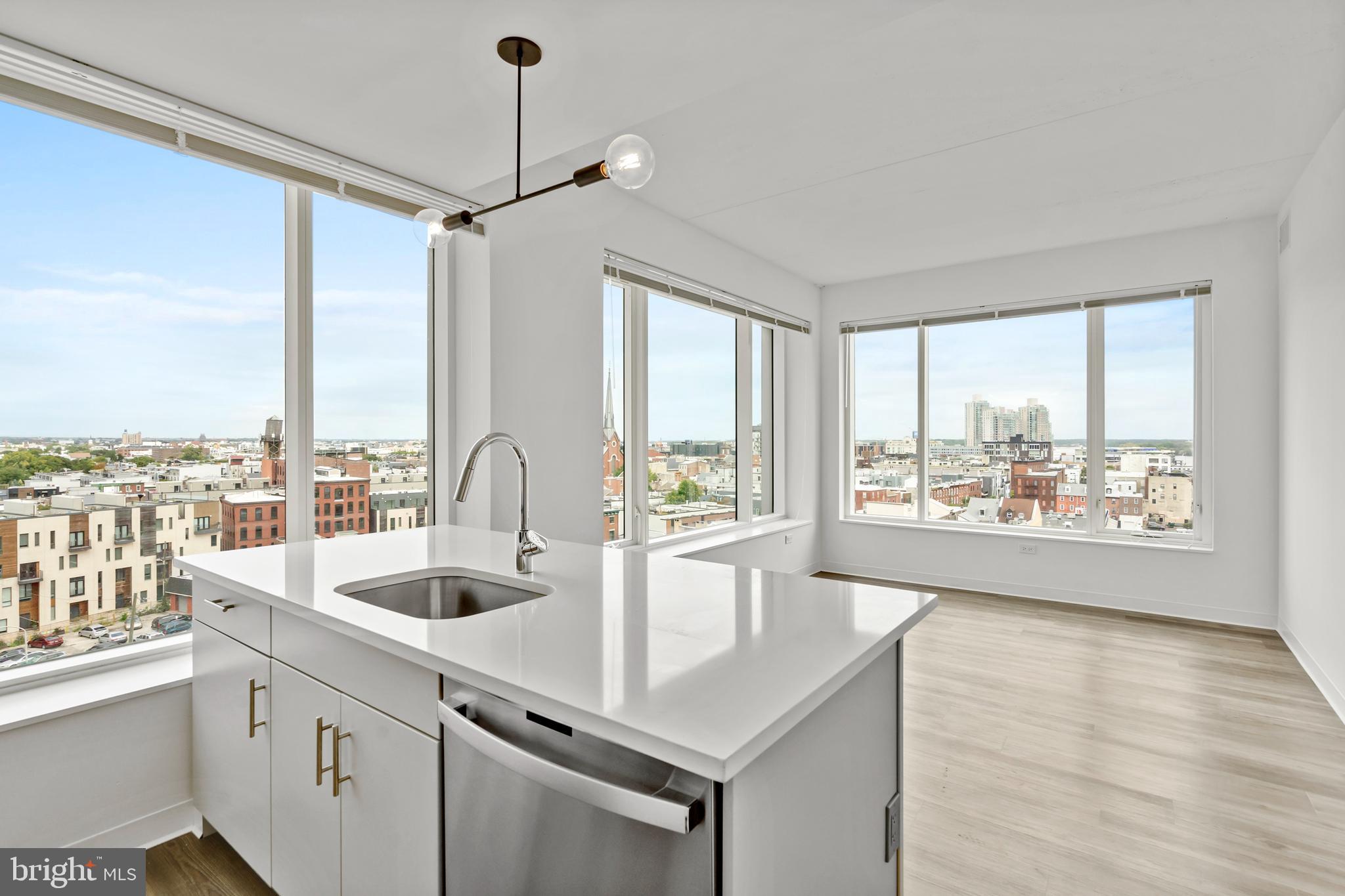 a kitchen with a sink and large windows