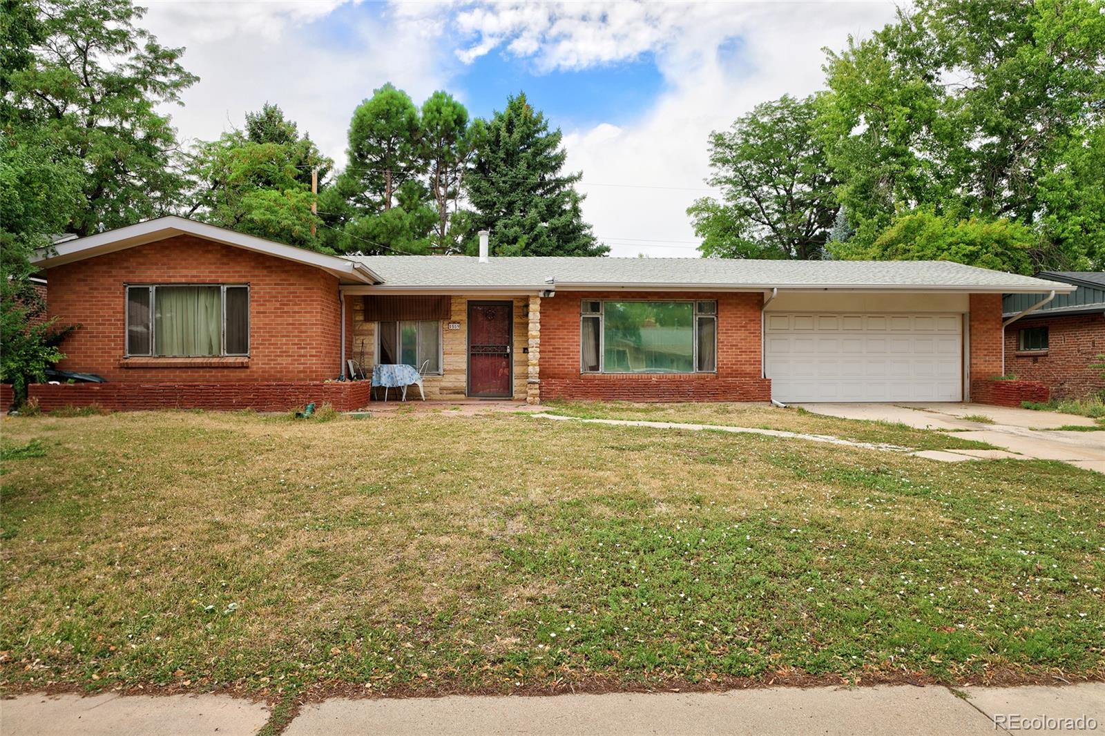 a front view of house with yard and trees around