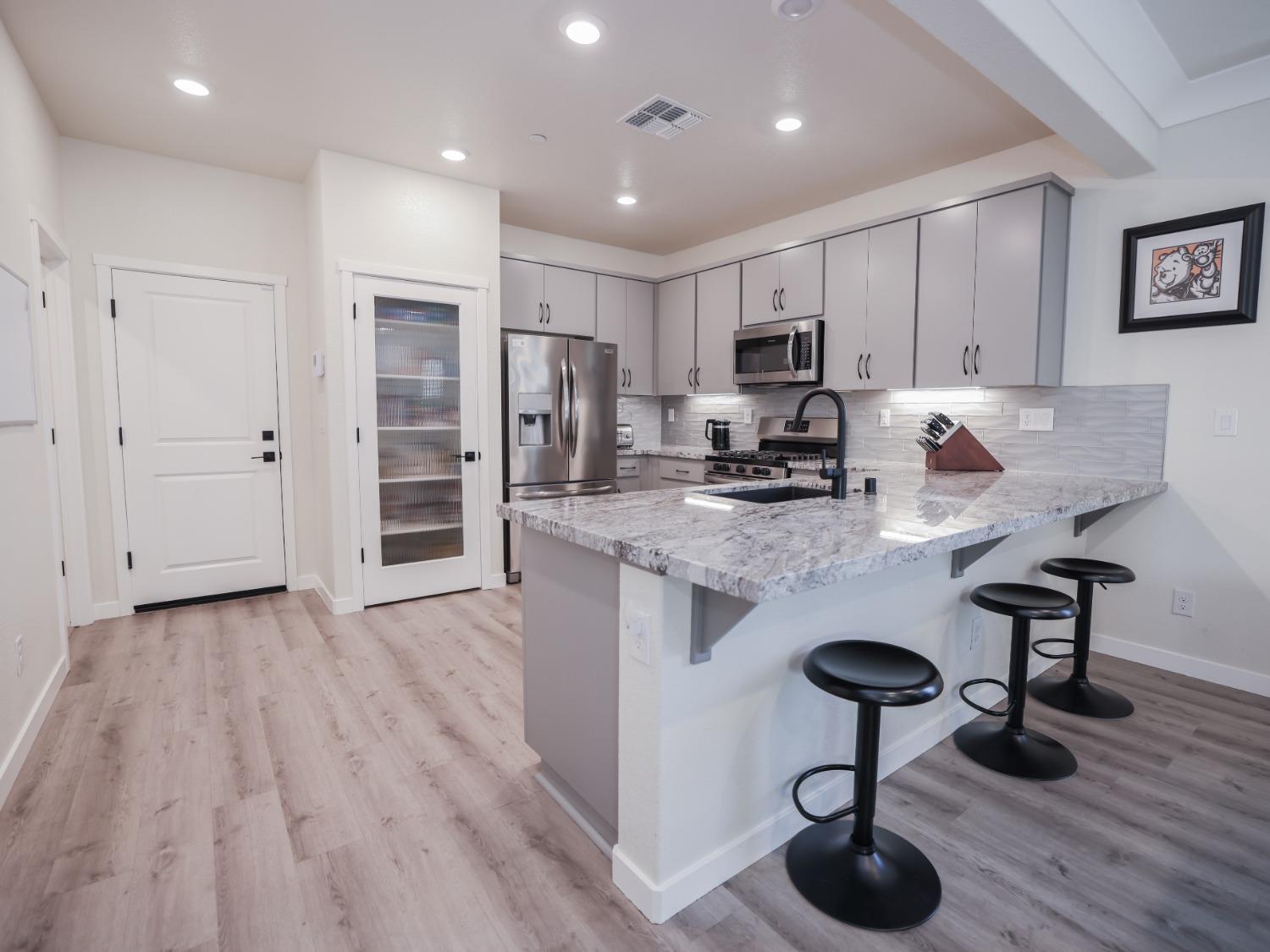 a kitchen with stainless steel appliances granite countertop a sink refrigerator and cabinets