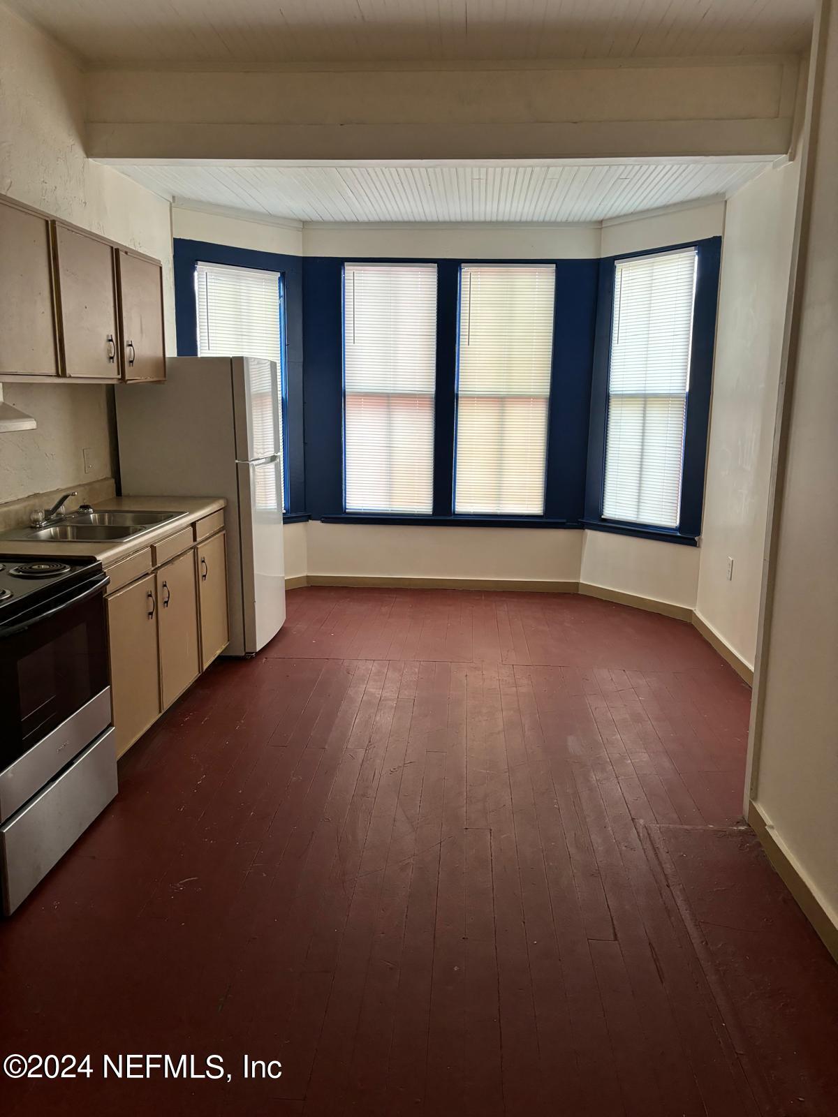 a kitchen with granite countertop wooden floors and wide window