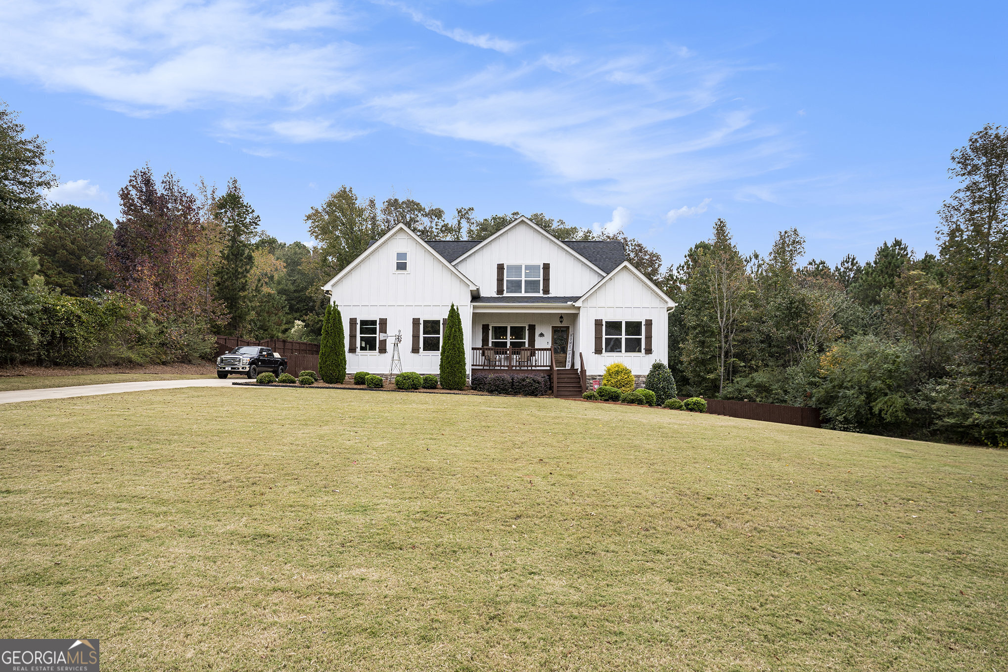 a front view of house with yard and trees in the background