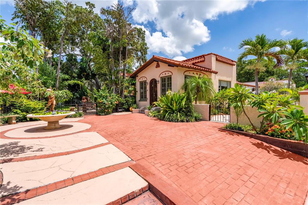 a front view of a house with a yard and potted plants