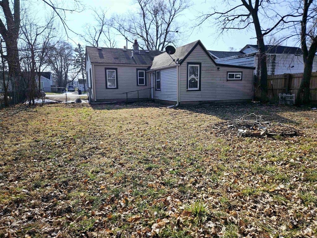 a view of a house with a large tree and a yard