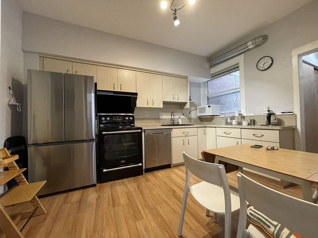 a kitchen with a refrigerator cabinets and wooden floor