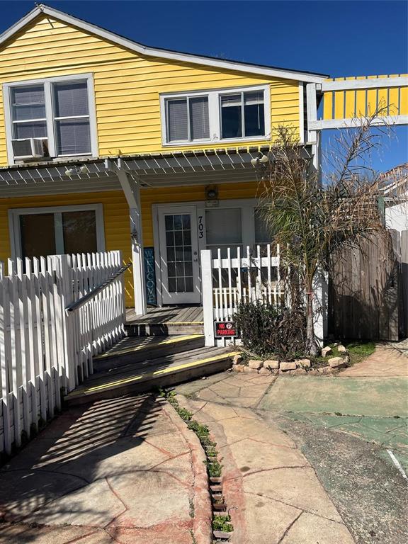 a view of a house with a small yard and wooden fence