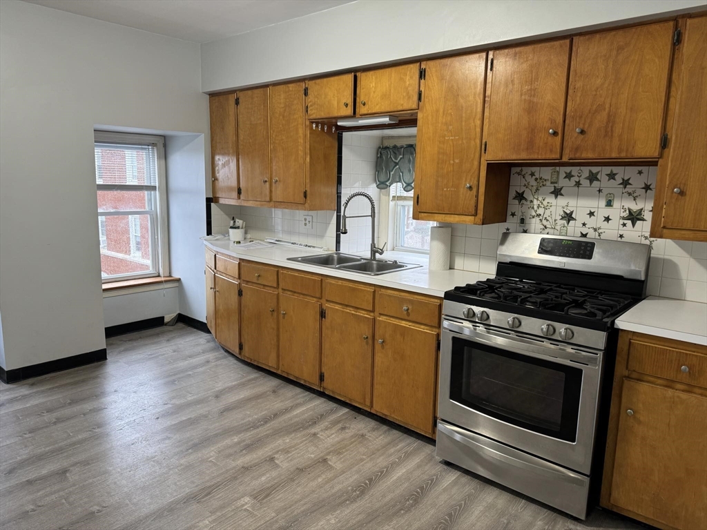 a kitchen with a stove a sink and a window