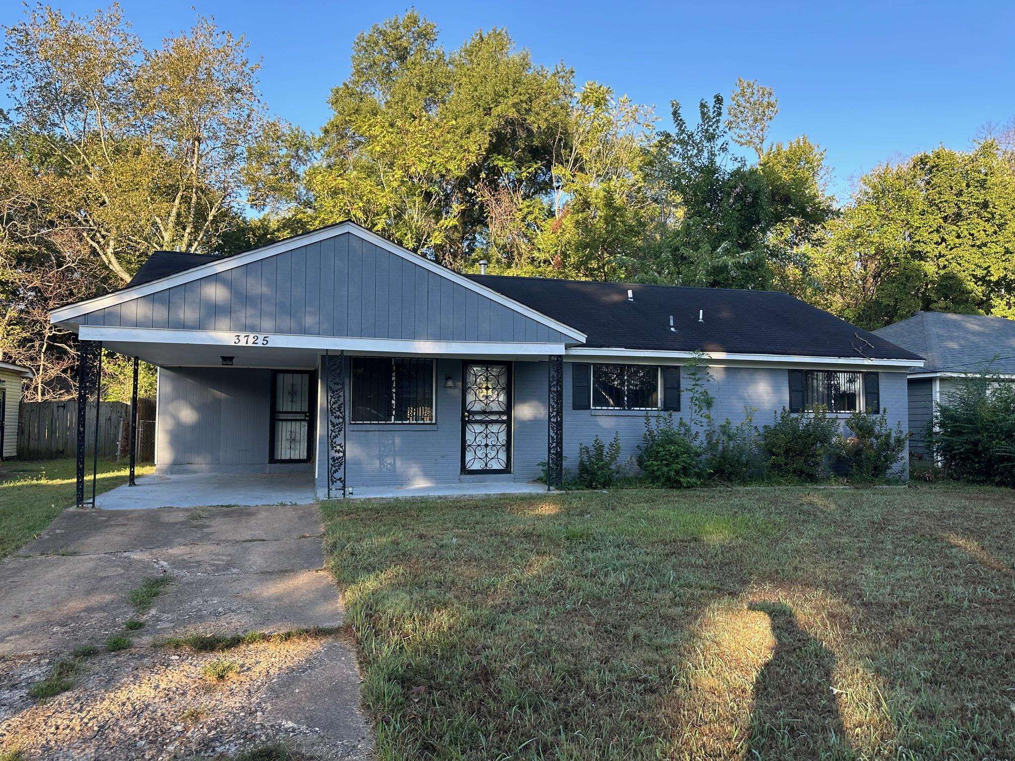 Single story home featuring a front yard and a carport