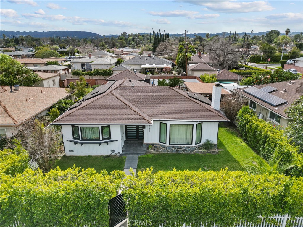 an aerial view of a house with a garden and lake view